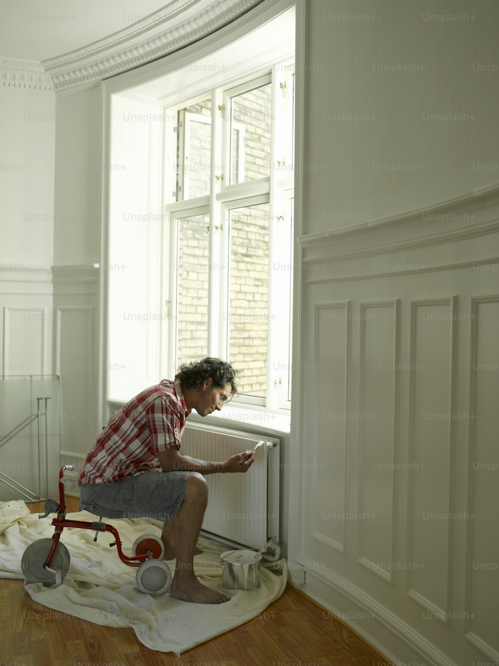 um homem sentado em uma cadeira em frente a uma janela