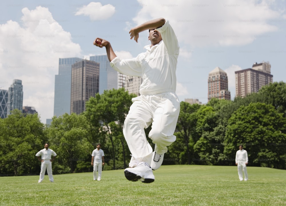 Un hombre saltando en el aire mientras juega un partido de cricket