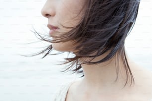 a close up of a woman's head with her hair blowing in the wind