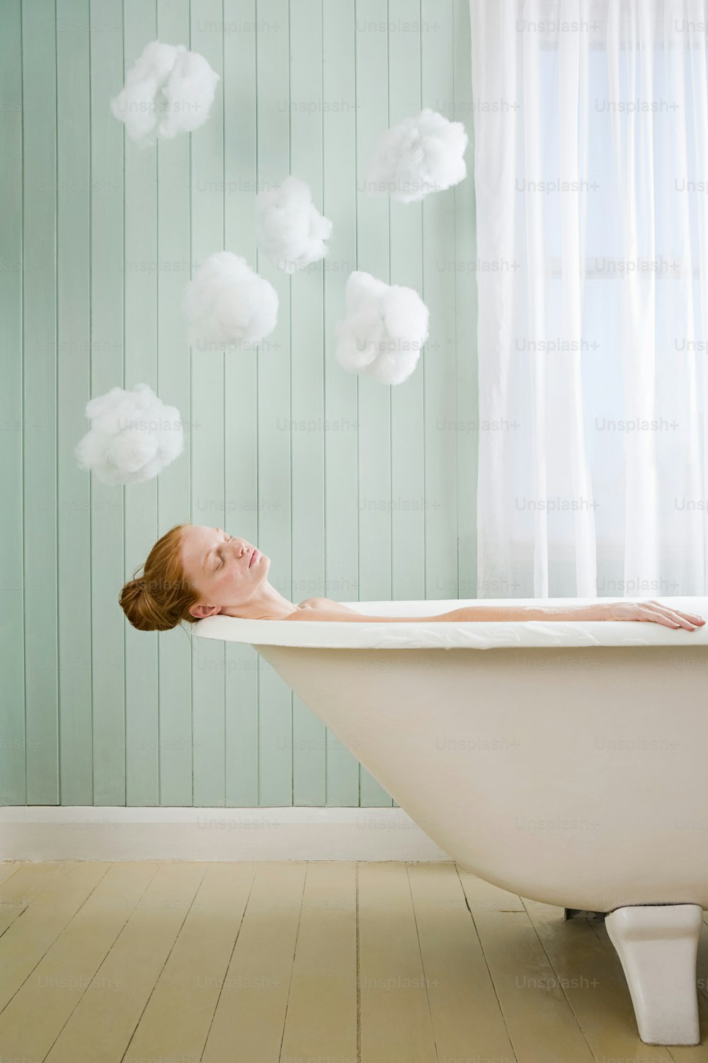 a woman laying down in a bathtub in a bathroom