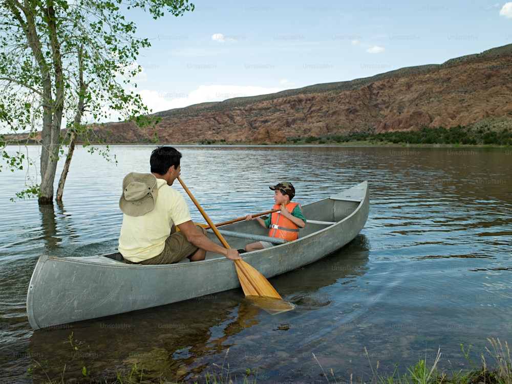 카누를 타고 노를 젓는 남자와 어린 소녀