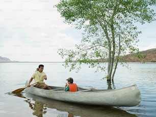 a man and a child in a canoe on a lake