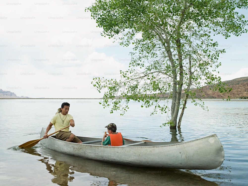 a man and a child in a canoe on a lake