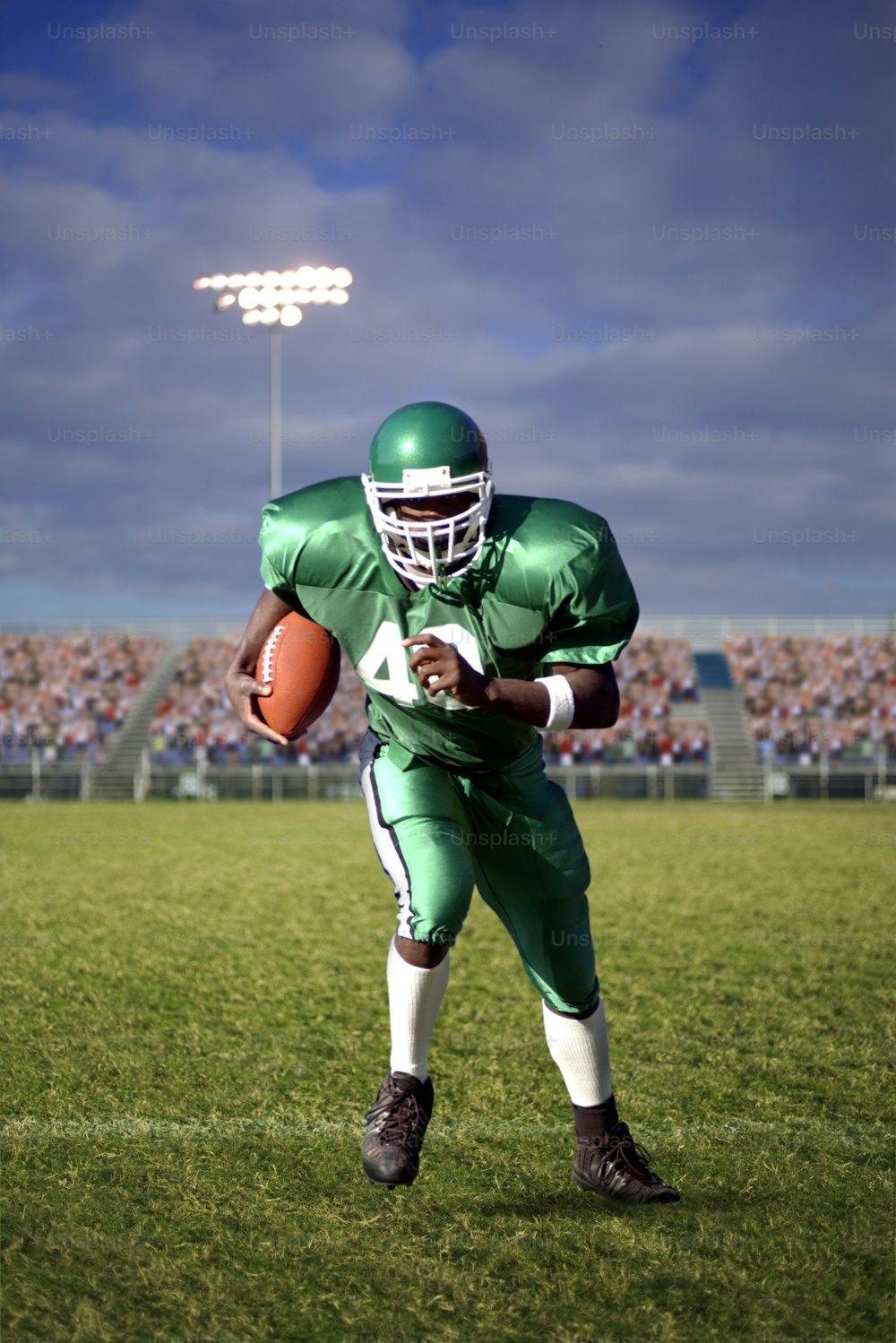 a football player holding a ball on a field
