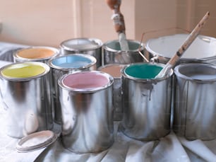 Un grupo de latas de pintura sentadas encima de una mesa