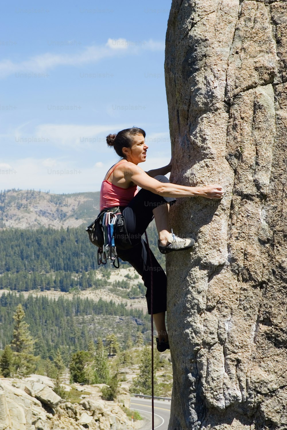 a woman climbing up the side of a mountain