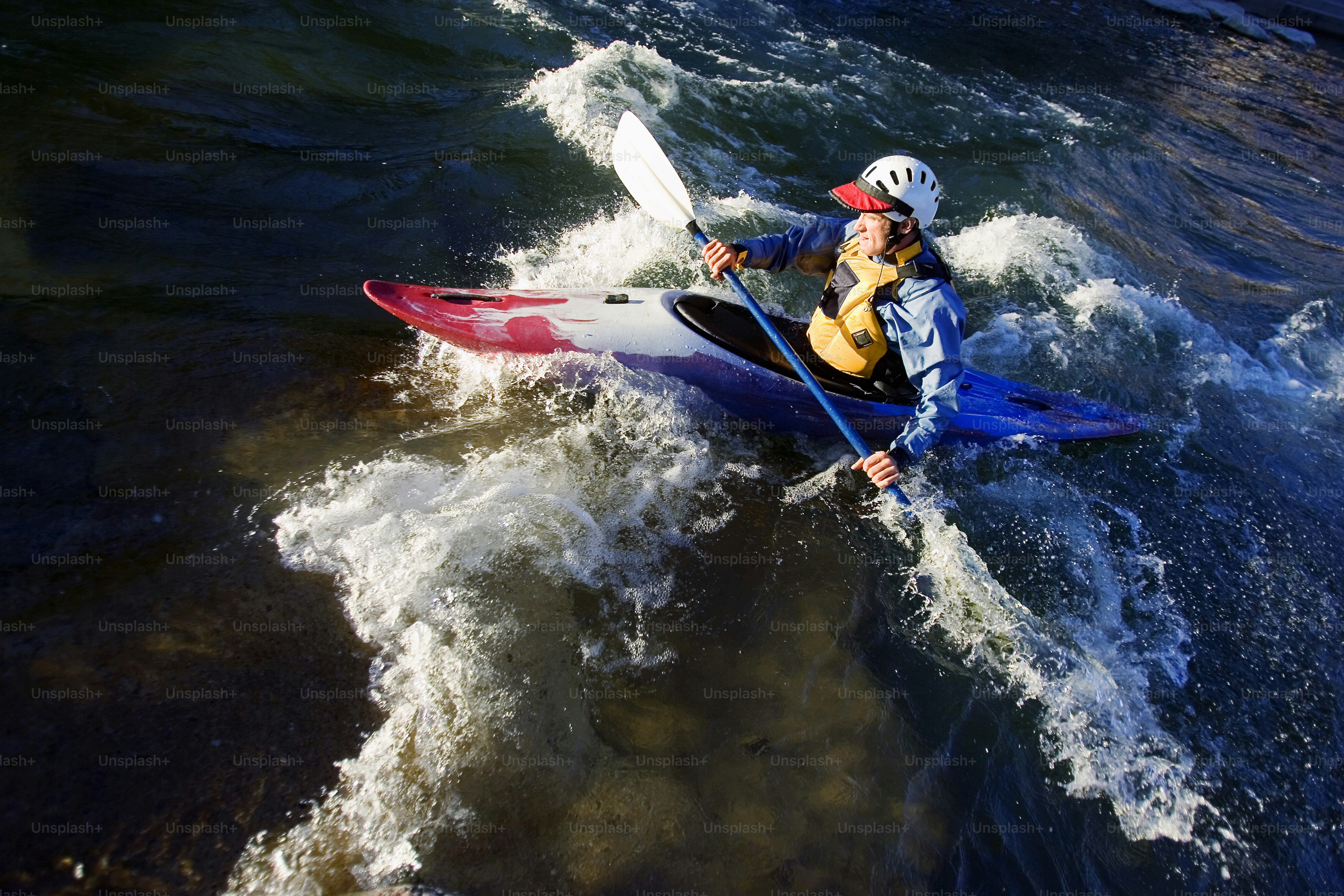A man riding a kayak on top of a body of water photo – Kayak Image on ...