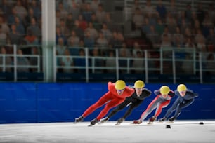 three speed skaters racing down a track in front of a crowd