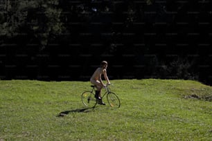 무성한 녹색 들판을 통해 자전거를 타는 남자