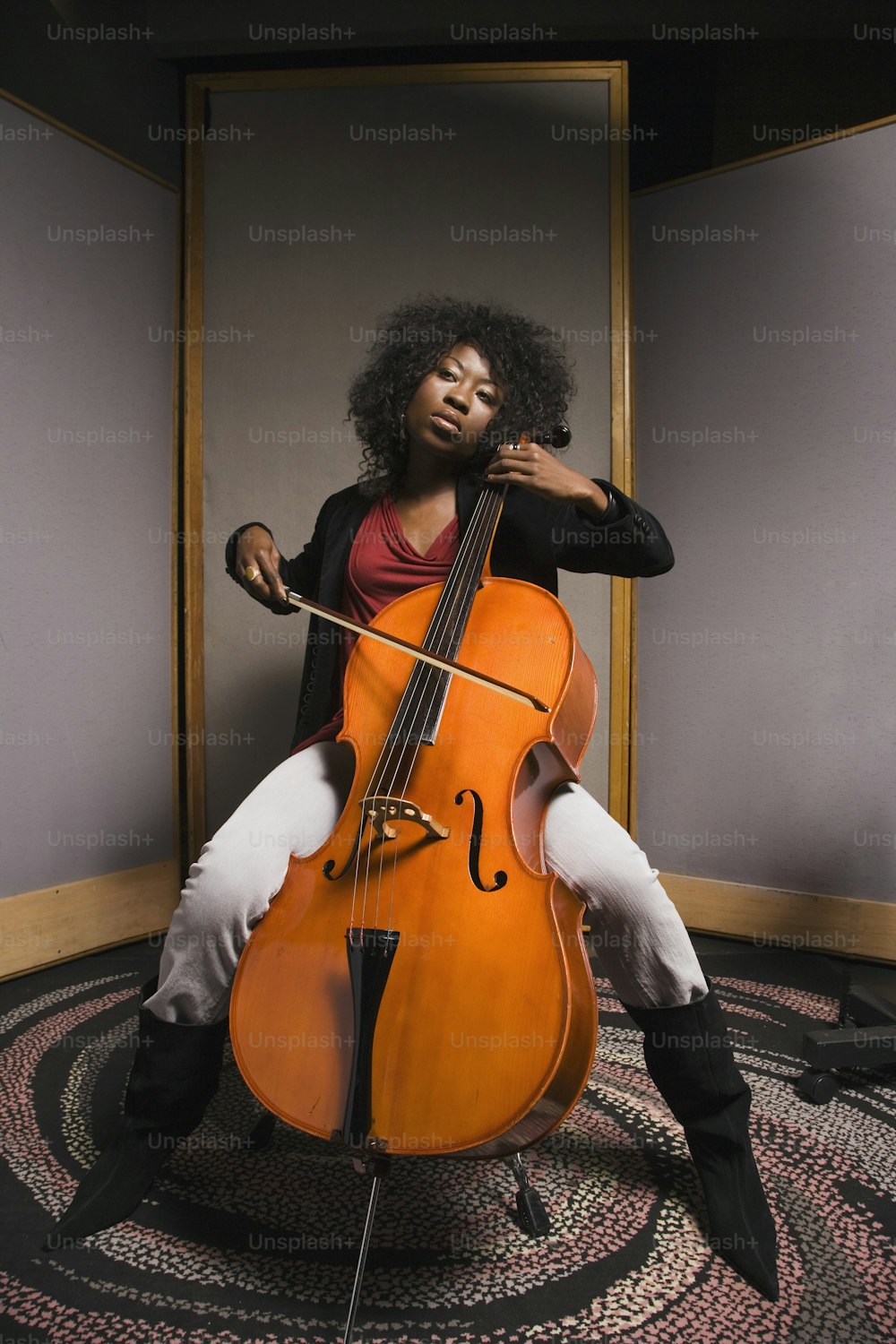 una donna seduta su una sedia che tiene un violoncello