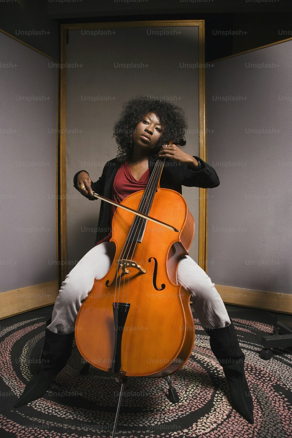 a woman sitting on a chair holding a cello