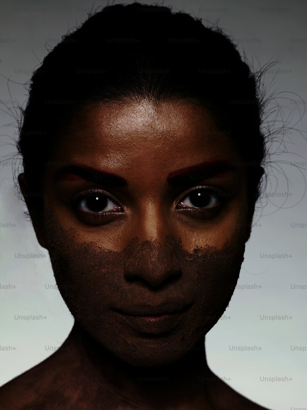 a woman's face is covered in clay