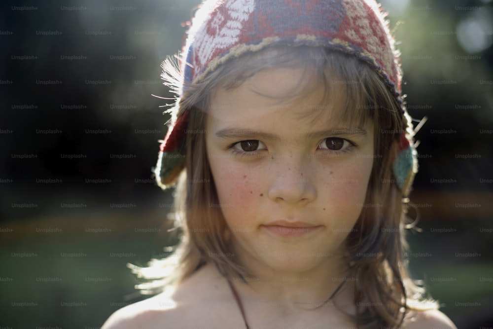 a close up of a child wearing a hat