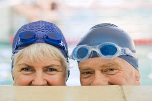 two older people wearing goggles and swimming caps