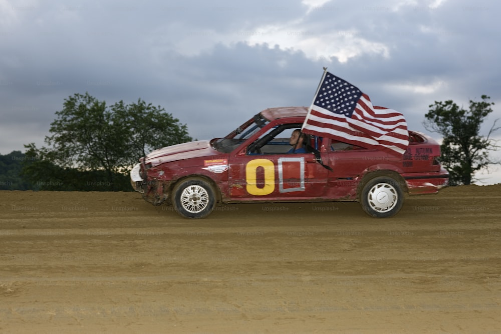 Race car taking a lap around the racetrack with the American Flag blowing out of the window.  