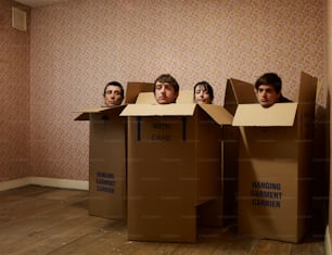 a group of men standing inside of cardboard boxes
