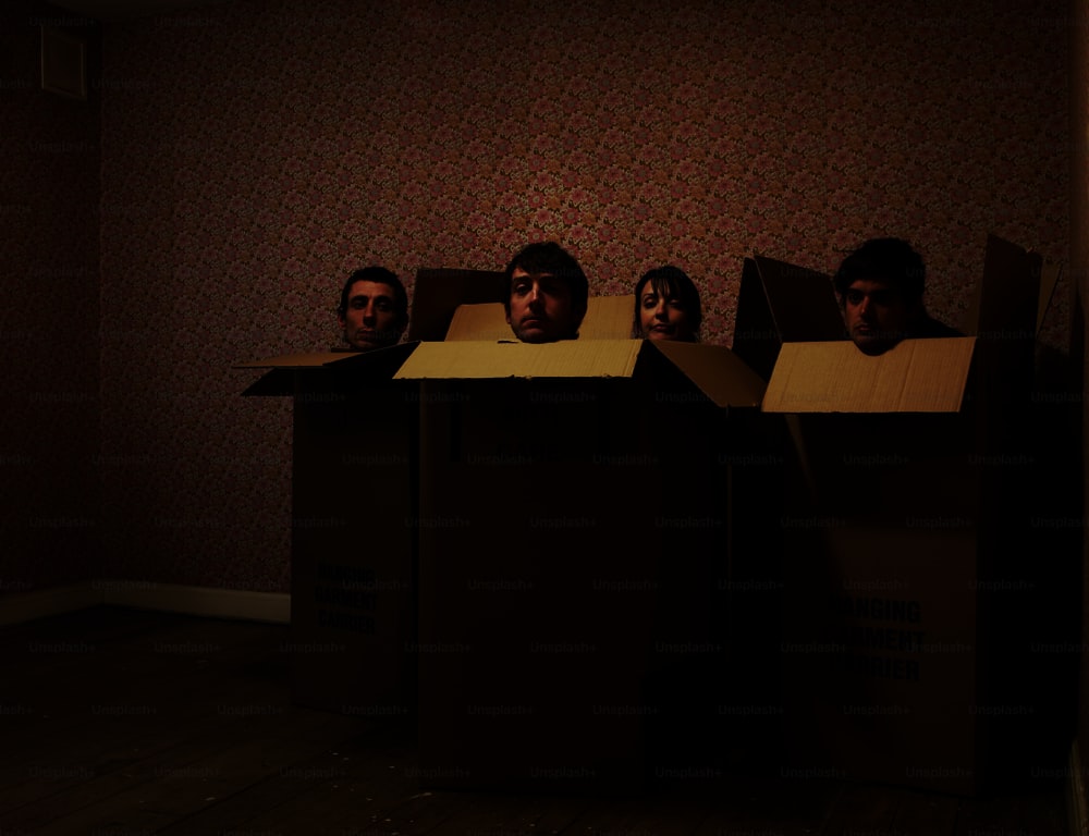 Un groupe d’hommes debout à l’intérieur de boîtes en carton