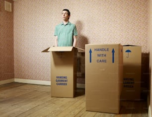 Un hombre parado frente a dos cajas de cartón