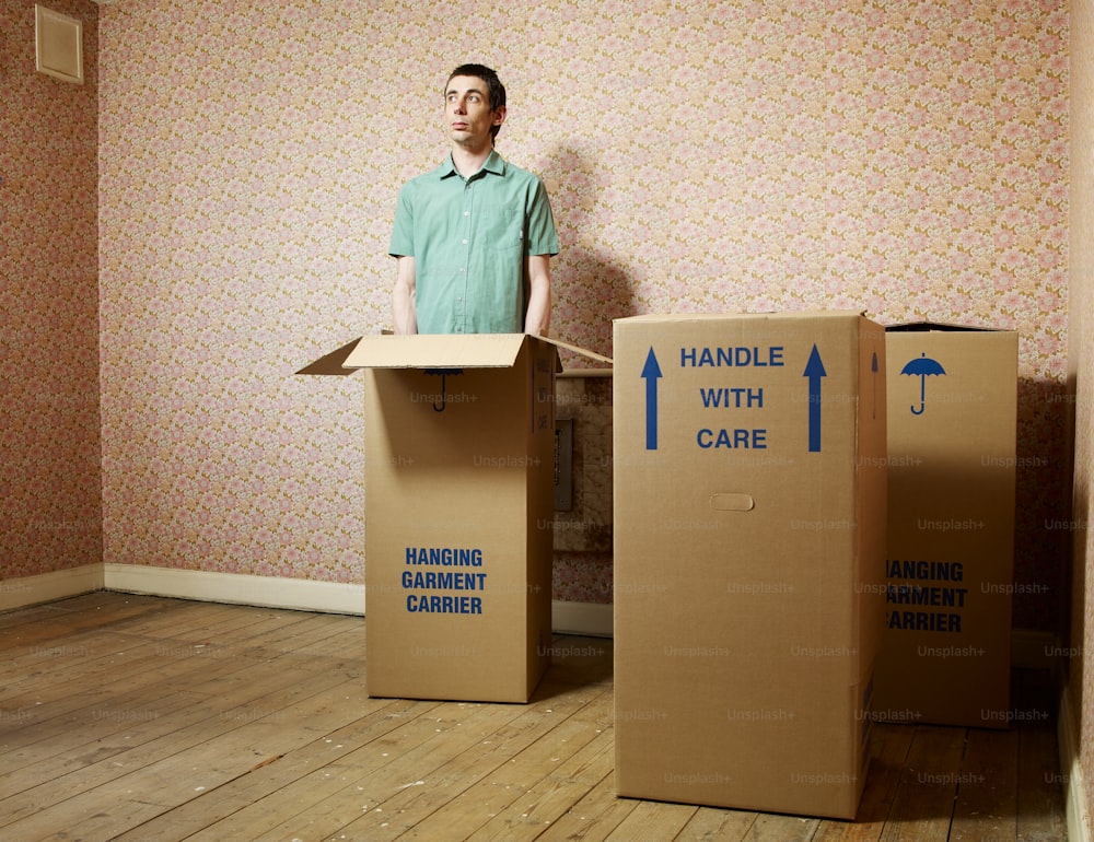 a man standing in front of two cardboard boxes