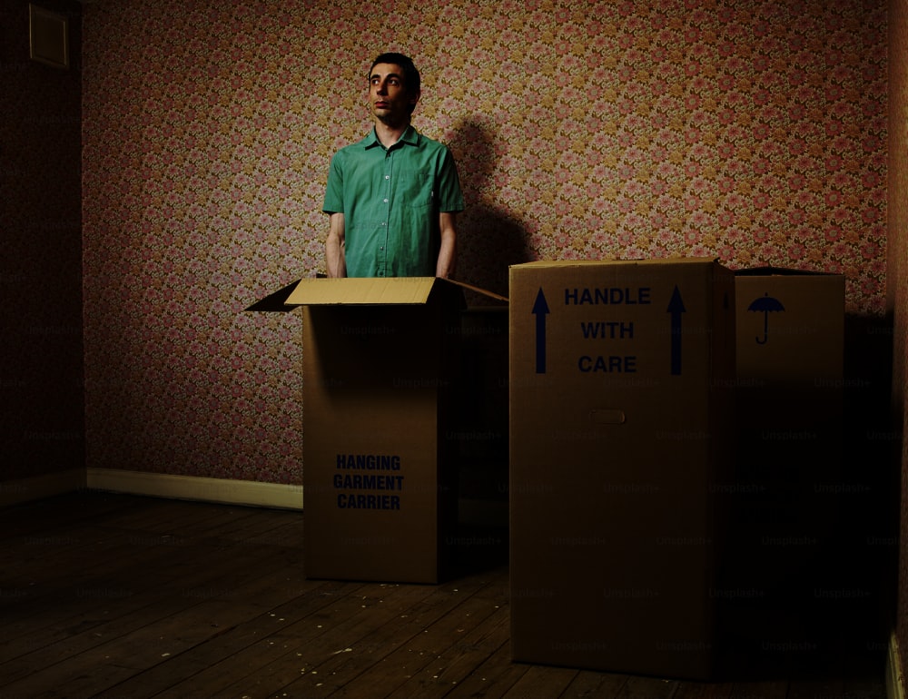 a man standing in front of two cardboard boxes
