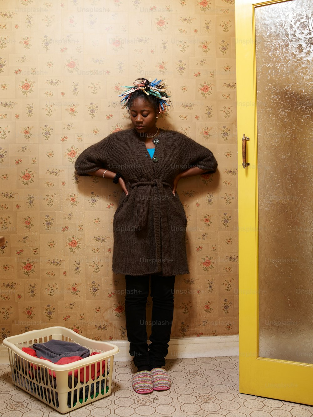 a woman standing in front of a door with her hands on her hips