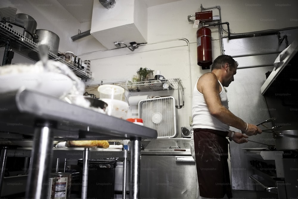 a man standing in a kitchen preparing food