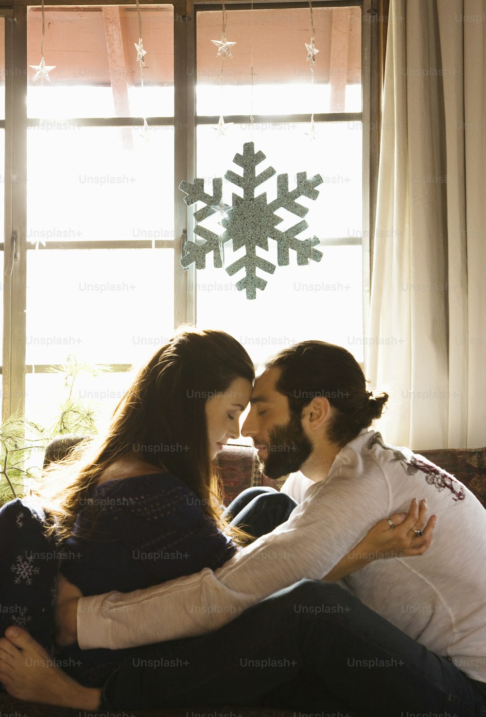a man and a woman sitting on a couch in front of a snowflake