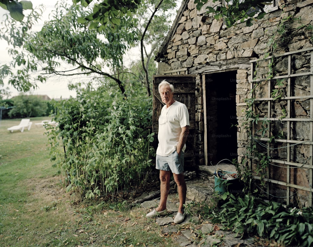 a man standing in front of a stone building