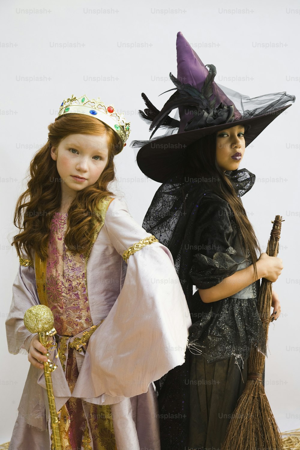 Zwei kleine Mädchen, die sich zu Halloween als Hexen verkleidet haben