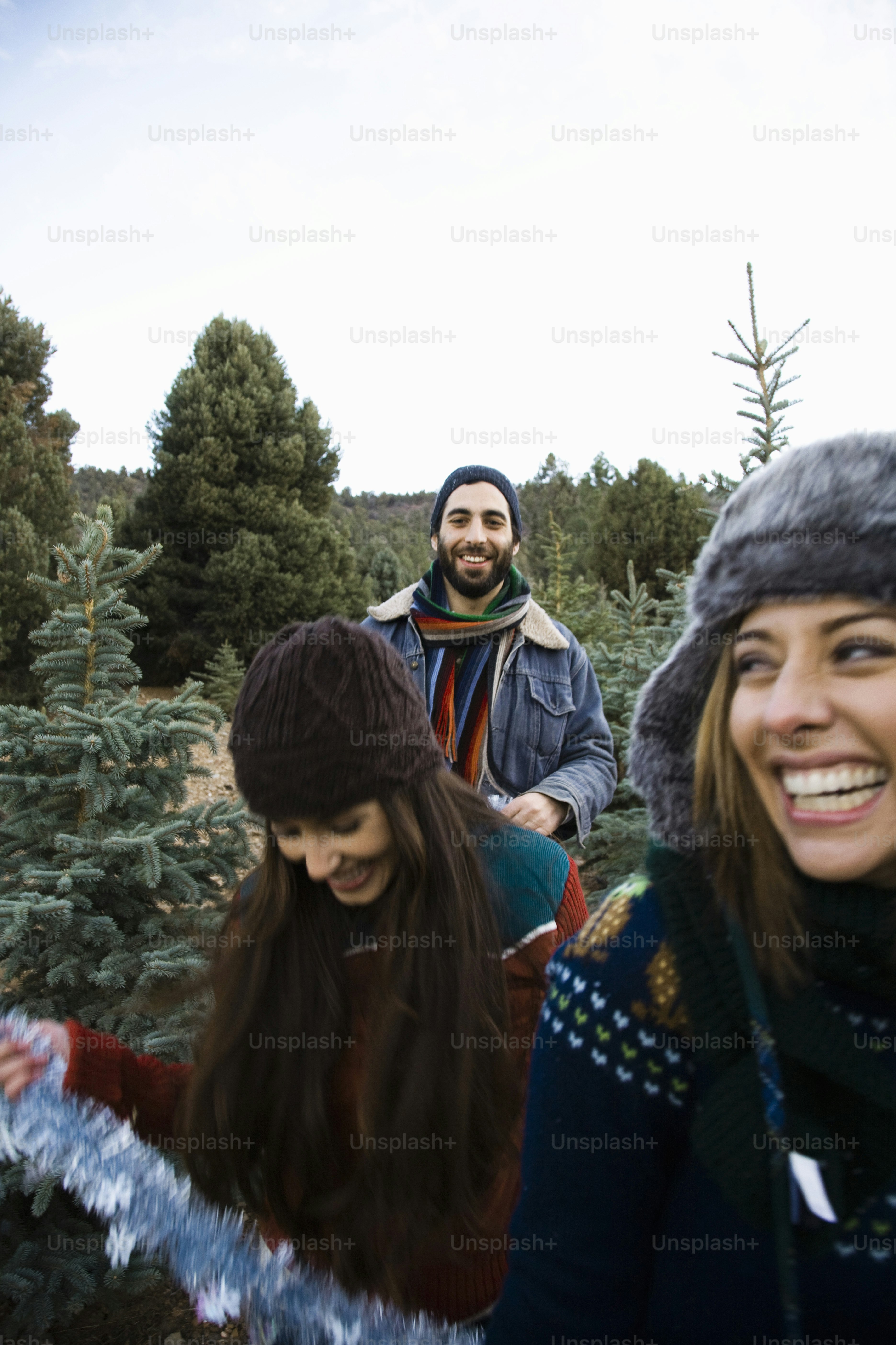 A group of people standing around a christmas tree photo – Christmas ...