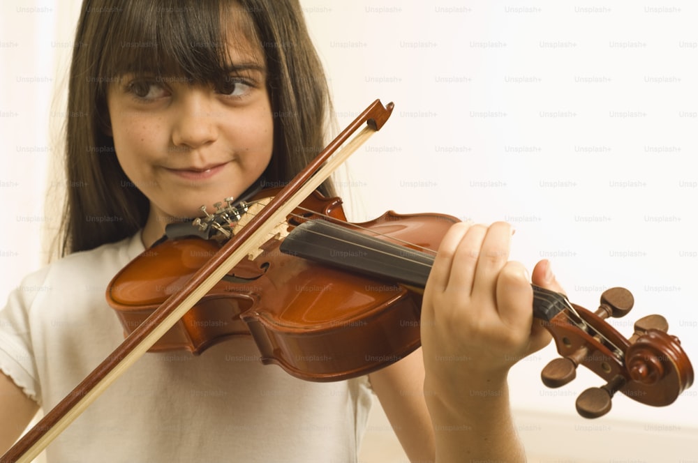a young girl holding a violin in her hands