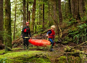 a couple of people in the woods with a canoe