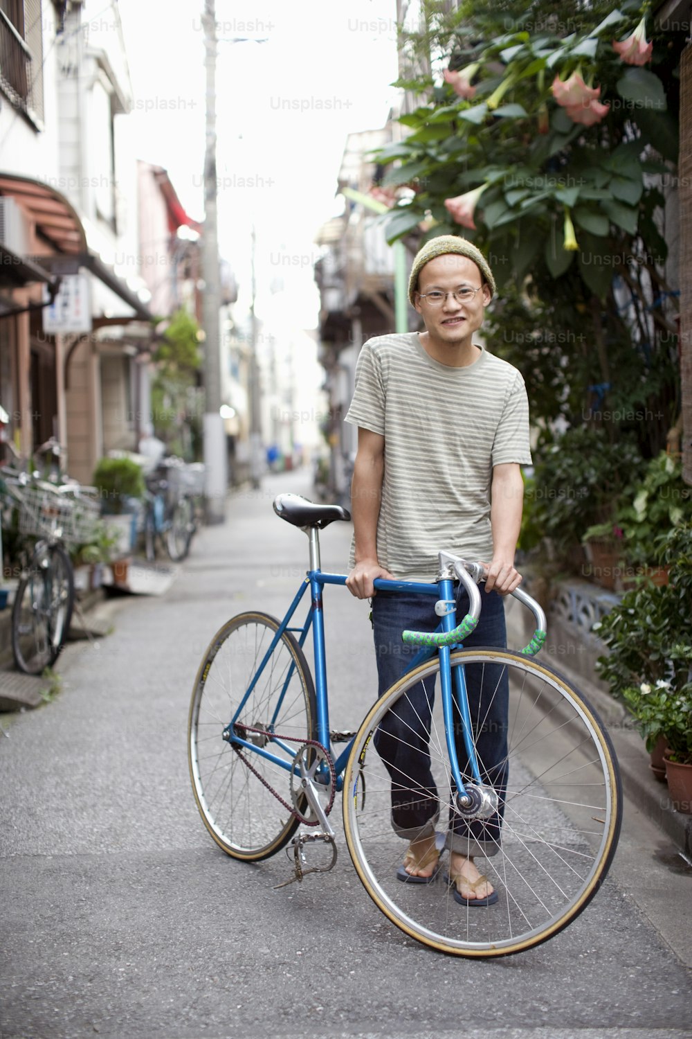 a man standing next to a blue bicycle