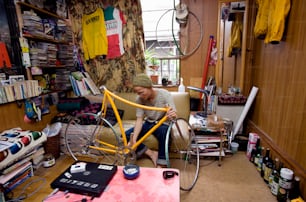 Ein Mann, der in einem Raum an einem Fahrrad arbeitet