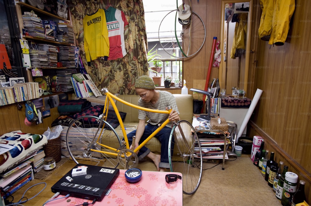 Ein Mann, der in einem Raum an einem Fahrrad arbeitet