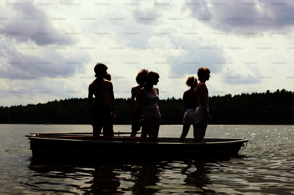 a group of people standing on top of a boat
