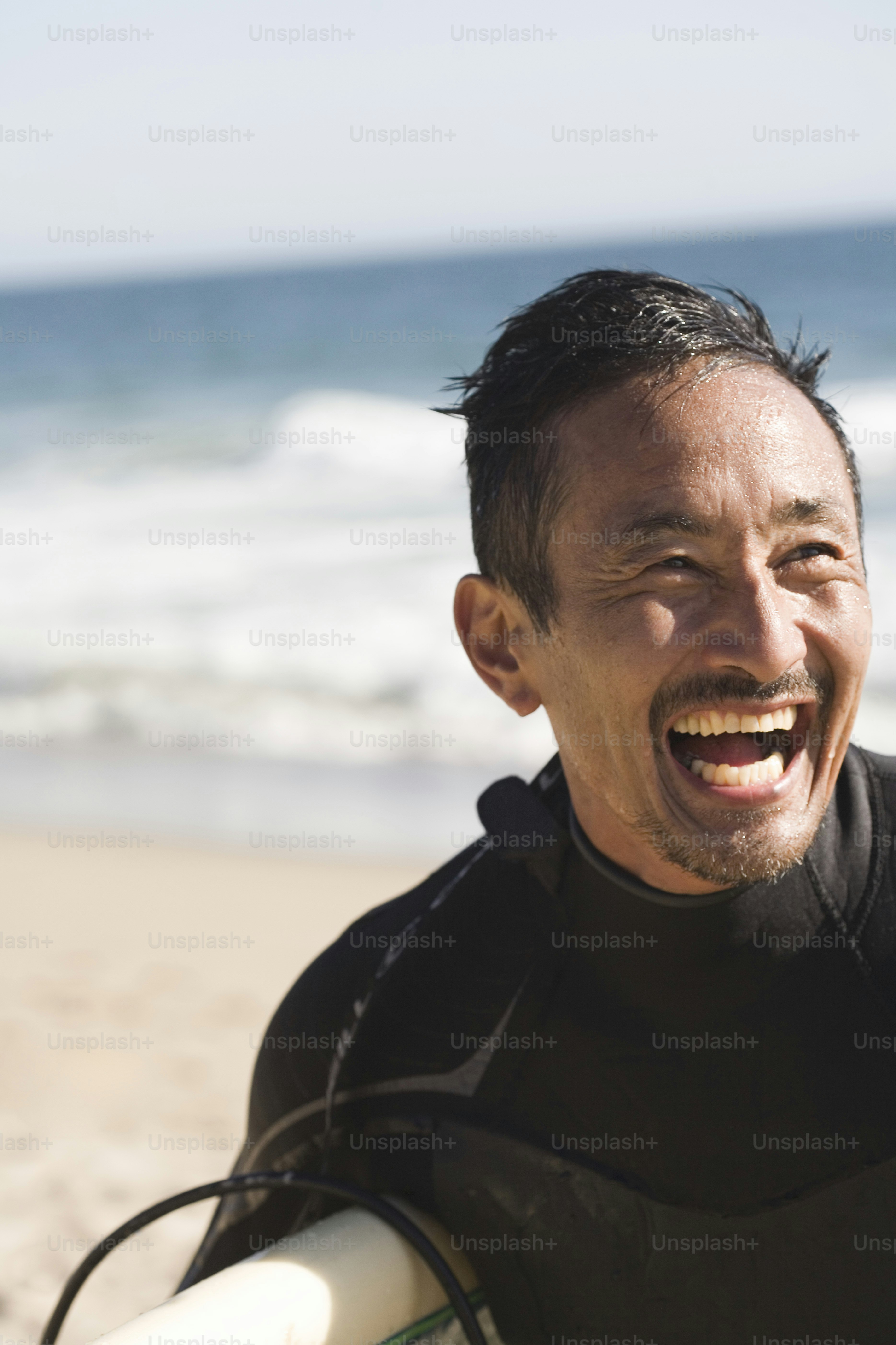 a man in a wet suit holding a surfboard