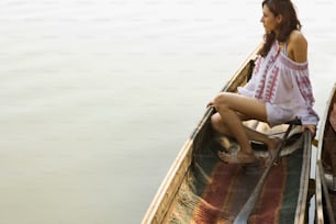a woman sitting in a boat on the water