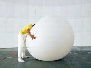 a man leaning against a large white object