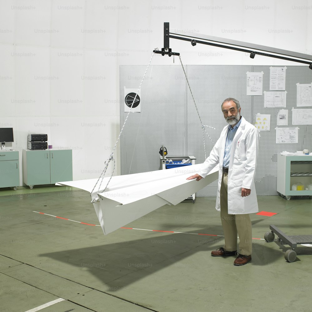 a man in a lab coat holding a paper airplane