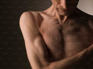 Un uomo a torso nudo con le braccia incrociate