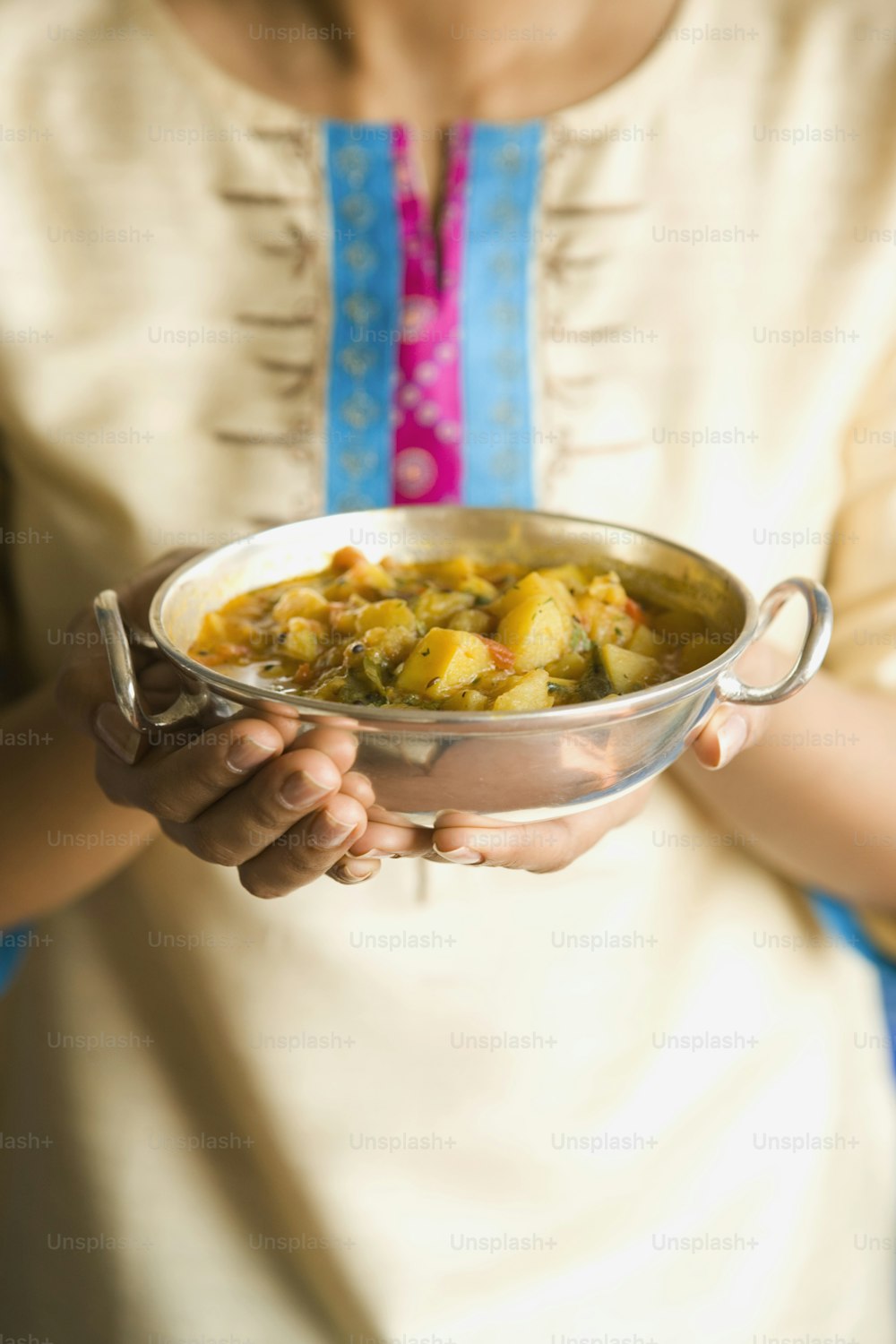 한 여자가 손에 음식 그릇을 들고 있다