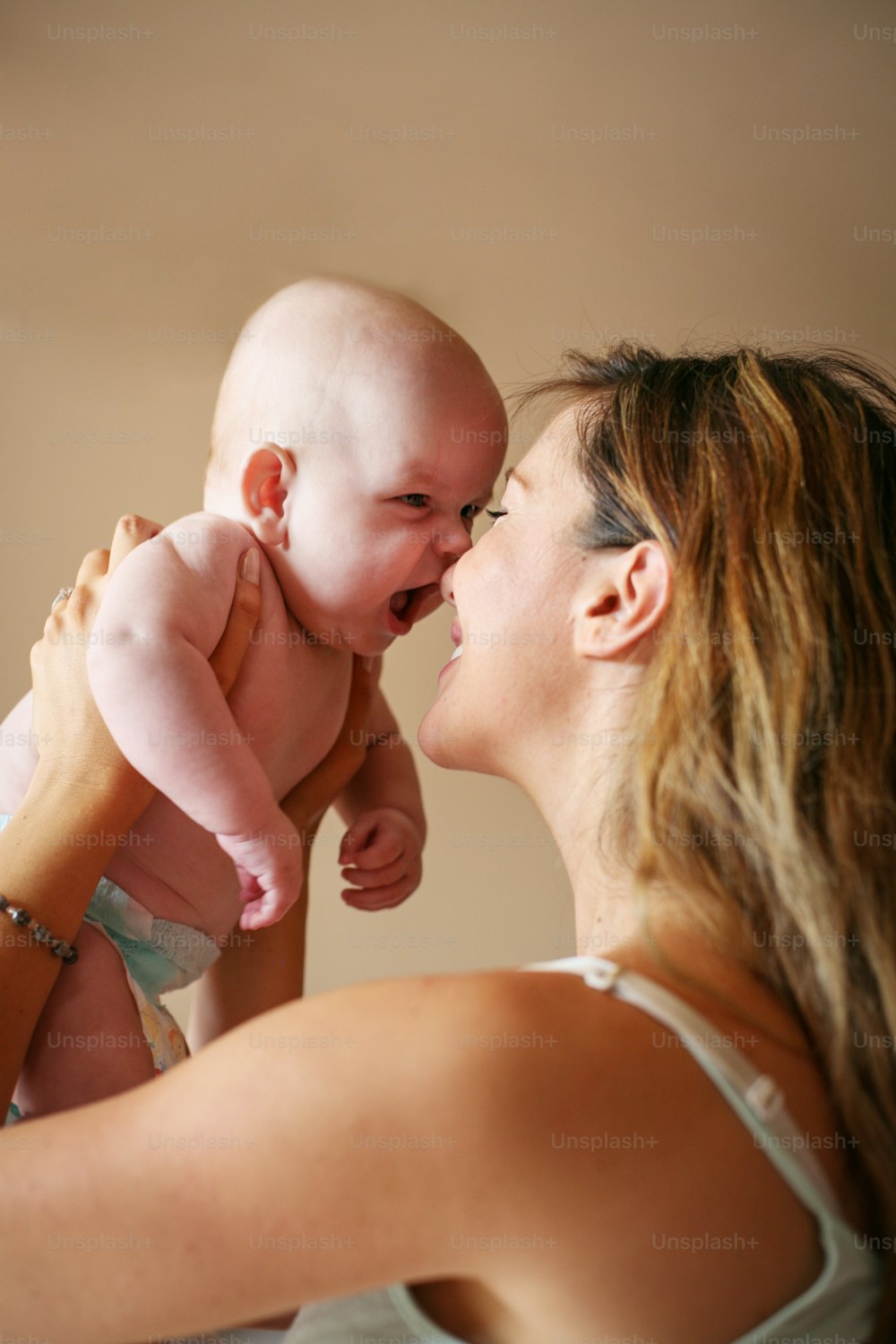 Young mother playing with her baby boy.  Mother enjoying in free time with her little cute baby.