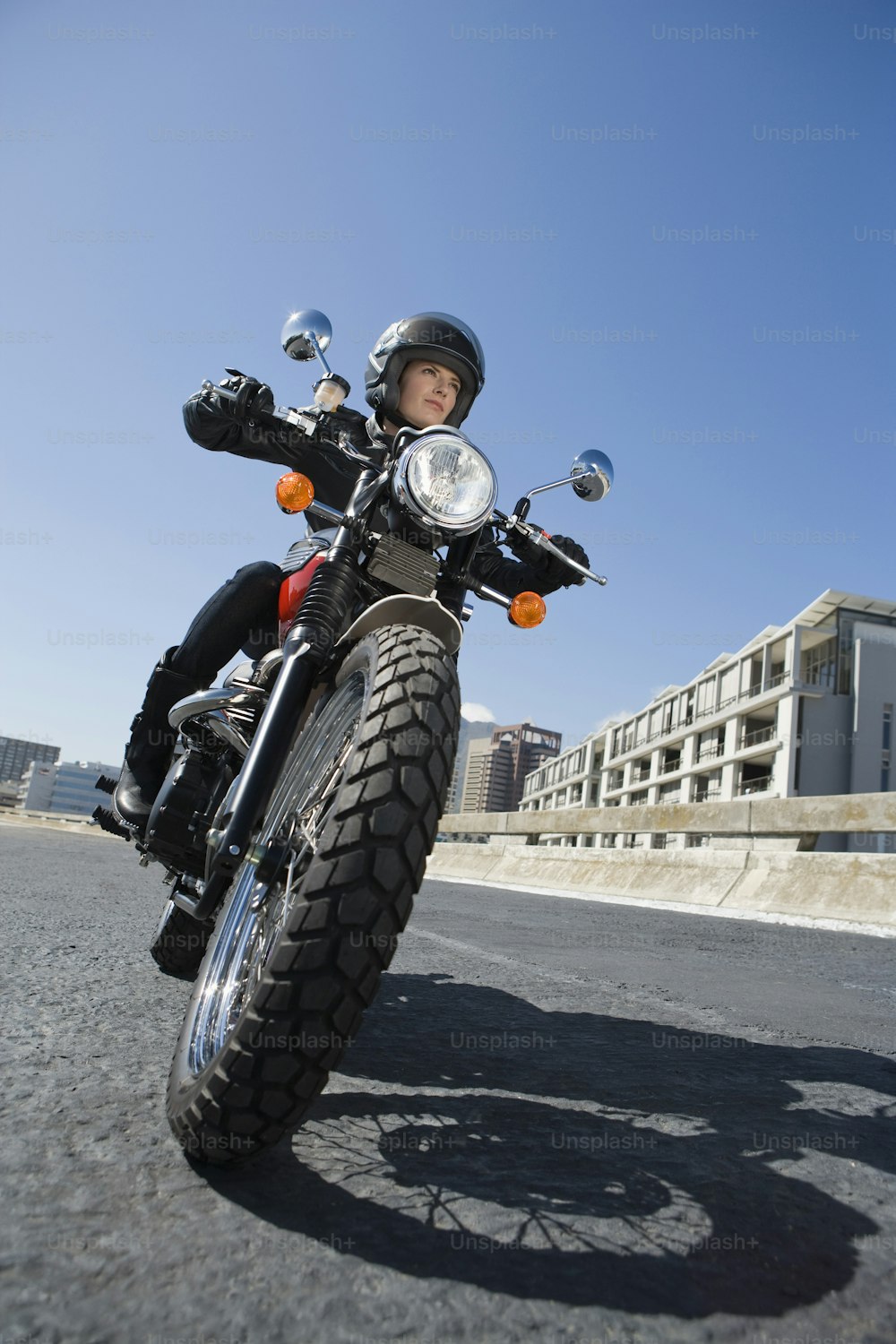 a man riding on the back of a motorcycle down a street