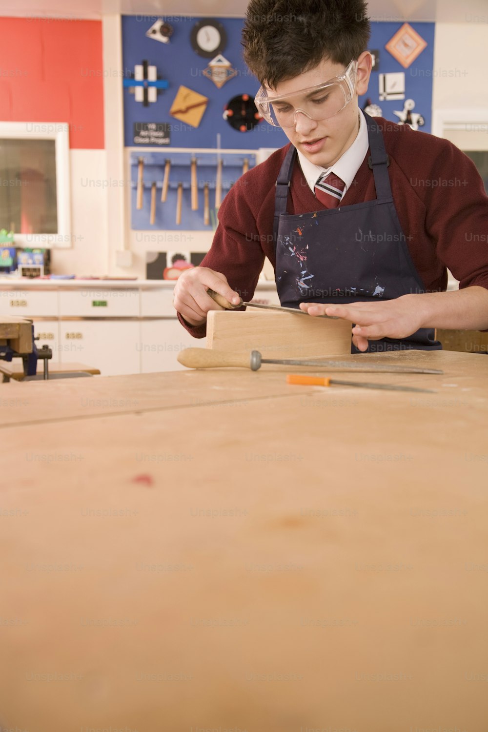 um jovem trabalhando em um pedaço de madeira