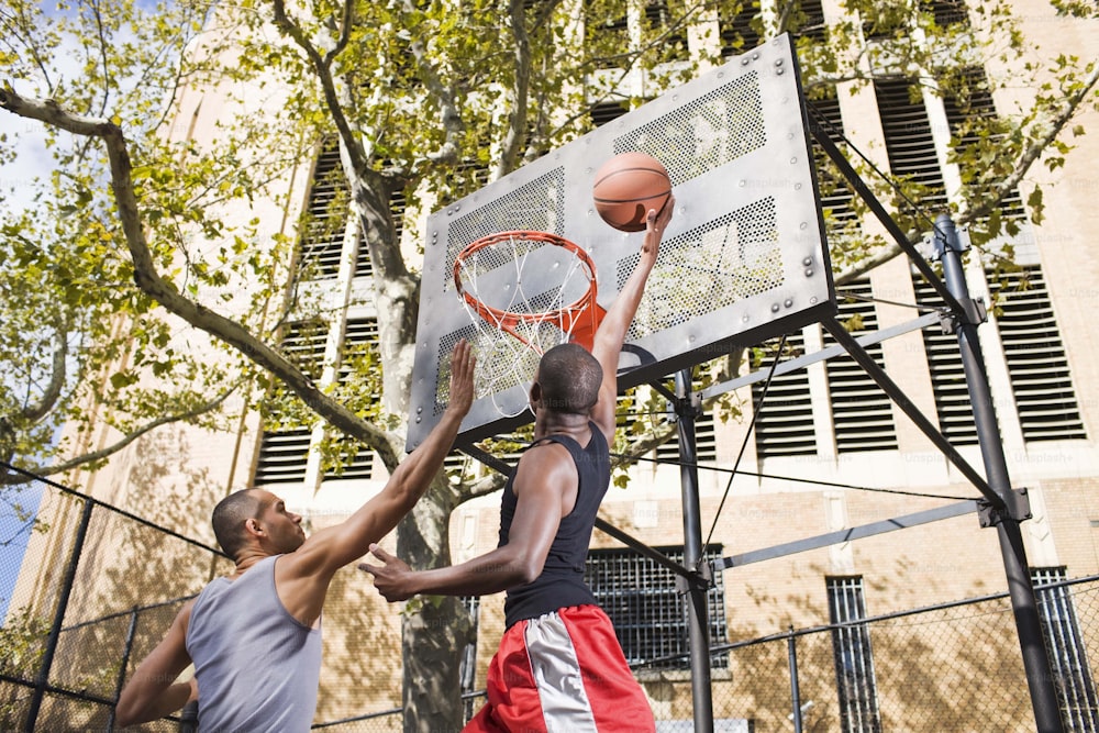 バスケットボールコートでバスケットボールをする2人の男性