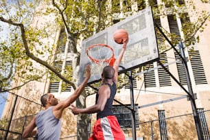 Dos hombres jugando baloncesto en una cancha de baloncesto
