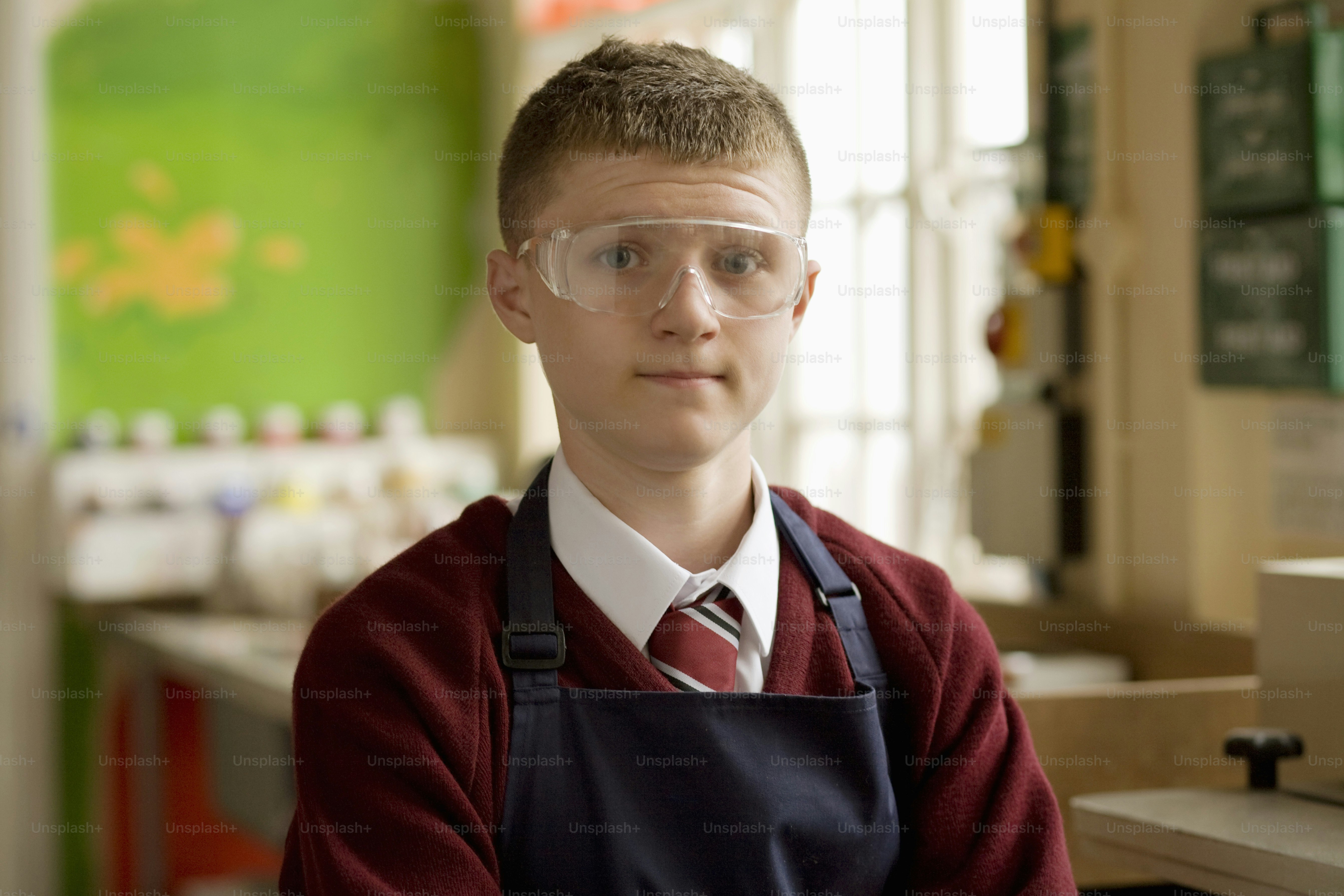 a young boy wearing glasses and a red sweater