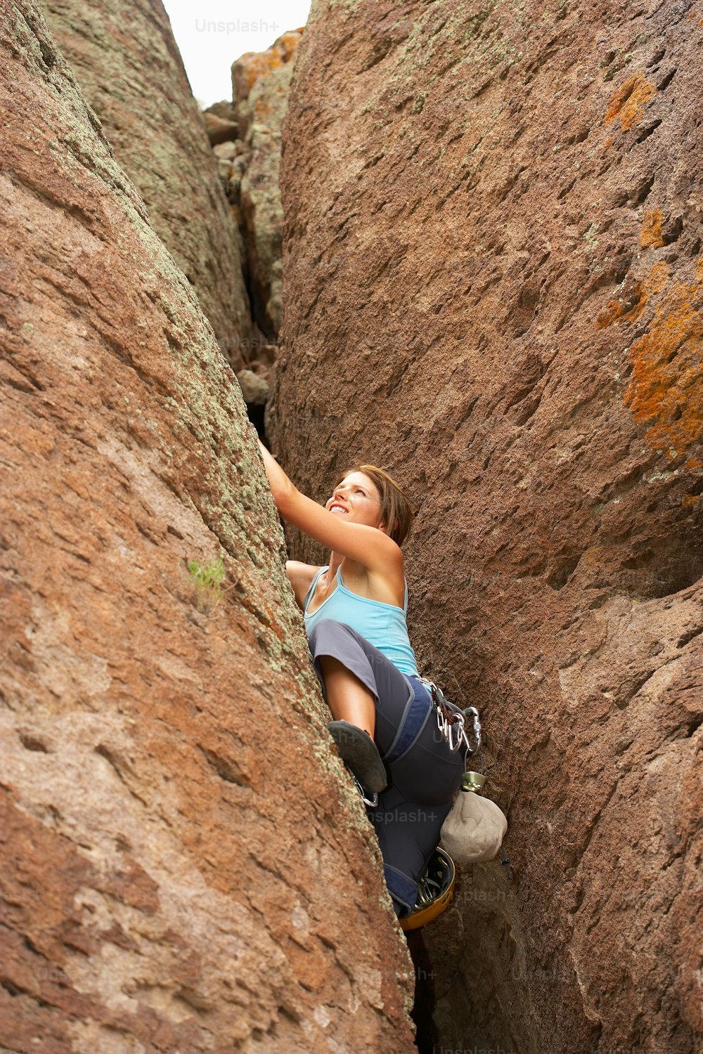 Une femme grimpe sur le flanc d’une montagne
