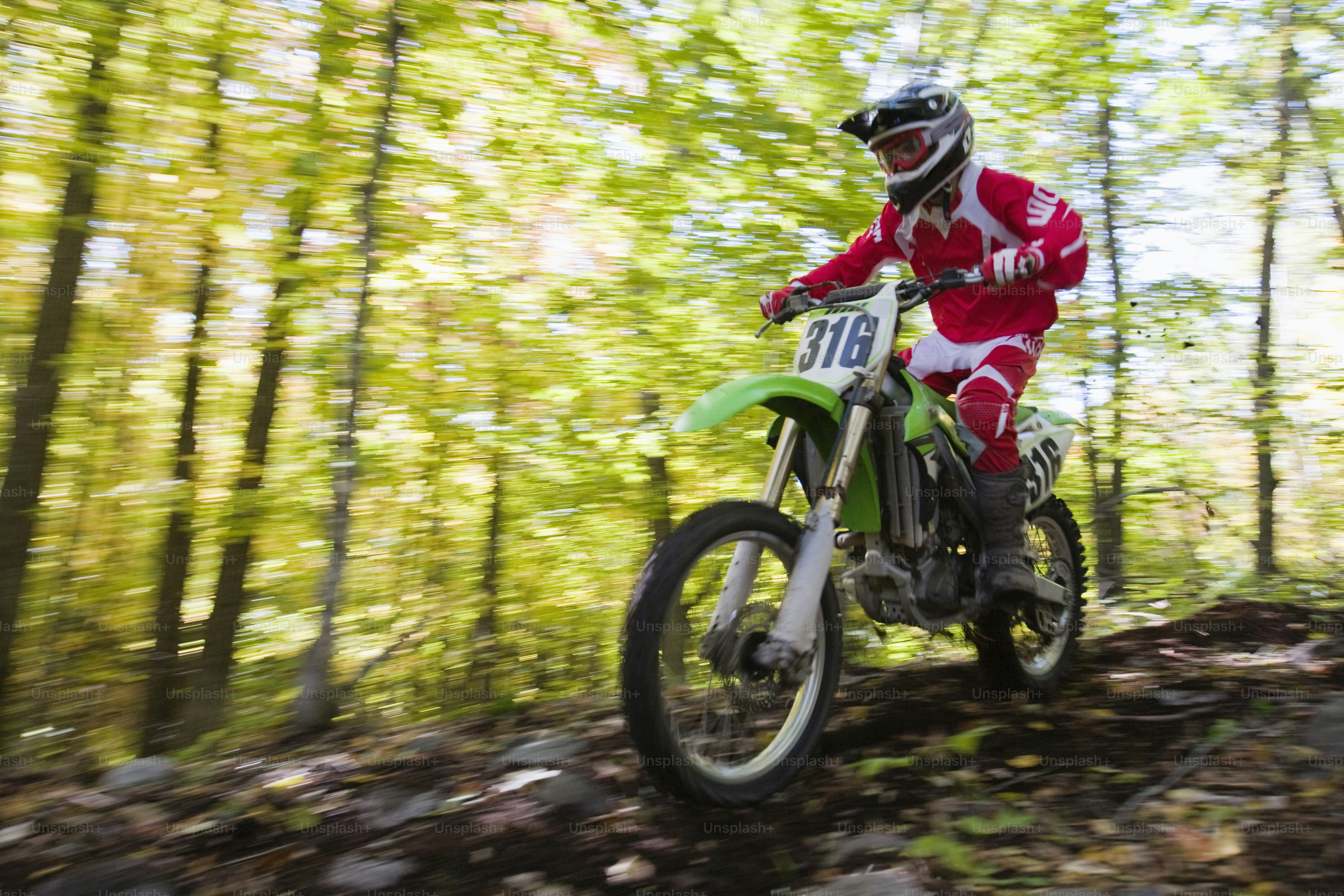 Ein Mann, der mit einem Dirtbike durch einen Wald fährt